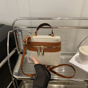 Minimalist beige canvas box bag with brown leather trim and golden double zippers