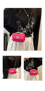 Detailed macro view of fuchsia quilted mini bag featuring pearl handle and silver chain strap