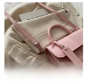 Detail showing the adjustable shoulder strap and woven texture of the pink crossbody bag