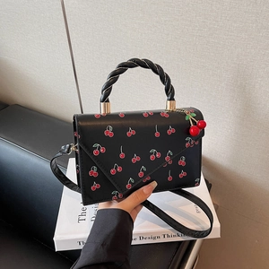 Fashionable black cherry print handbag with woven handle and adjustable crossbody strap
