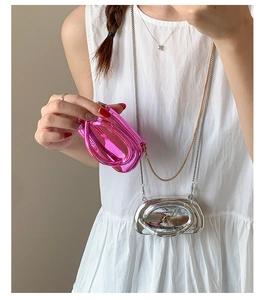 Macro detail of glossy metallic mini crossbody bag with sleek chain strap