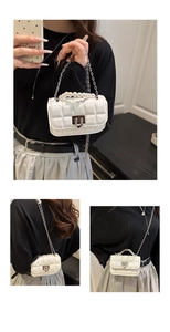 White quilted mini bag showing pearl handle detail and silver chain strap versatility