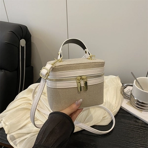 Chic beige canvas box bag with white leather trim and gold zippers, handheld style