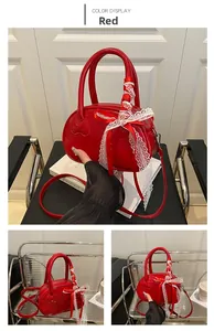 Detail of red oval handbag with heart texture, lace ribbon handle and long shoulder strap