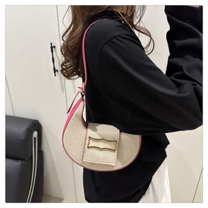 Detail of beige woven canvas crescent bag with pink leather trim and gold buckle