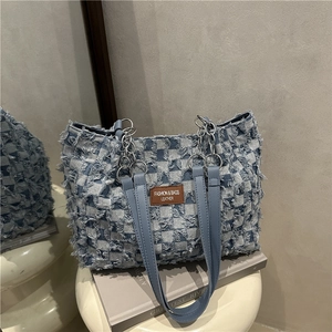 Fashionable large denim tote bag with blue fringe and leather chain handle for daily commute