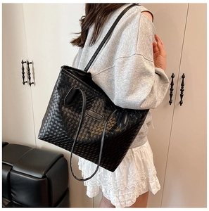 Detail of a large black woven tote bag with leather texture for office commute