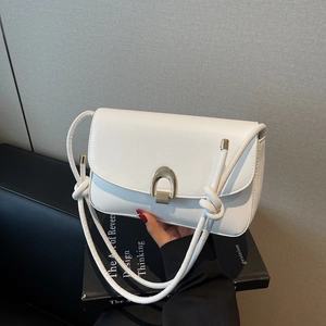 White glossy leather underarm bag with gold U-buckle and knotted strap detail