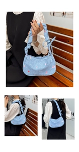 Close-up of light blue floral underarm bag with pleated handle and pink flower pattern