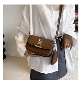 Detailaufnahme der dunkelbraunen Leder-Satteltasche mit Goldschließe und Minibeutel