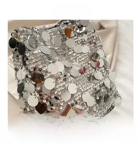 Detailed view of shiny silver oversized sequins on fashion bucket bag with metal chain