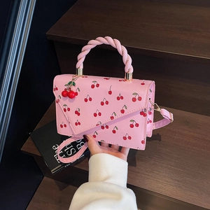 Pink PU leather tote bag with cherry print, twist handle and red cherry charm accessory