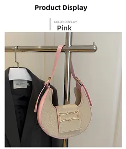 Detailed shot of pink leather and beige woven crescent shoulder bag with golden buckle