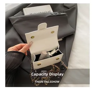 Internal view of a small white chain bag showing capacity for lipstick and makeup items