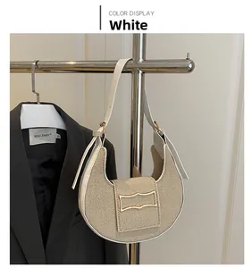 Detailed view of hobo bag with beige woven fabric, white leather trim and gold buckle