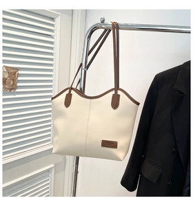 Detail of cream white tote bag with brown contrast trim and Fashion Bags leather label