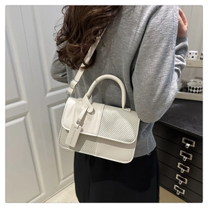 Detail of a beige crossbody bag with premium leather and woven fabric texture mix