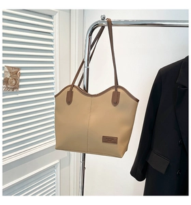 Detail of minimalist beige tote bag with brown straps and FASHION BAGS logo patch