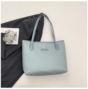 Detail of light blue woven leather tote bag with long straps and brand label detail
