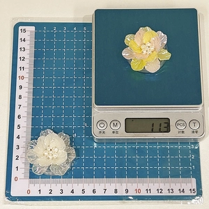 Detailed view of floral shell phone grip measuring approximately 4.5cm on a blue scale