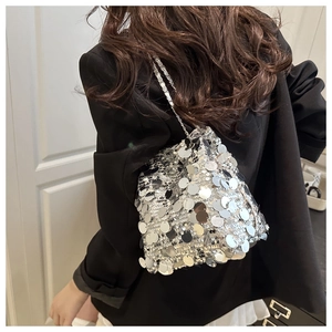 Détail de paillettes argentées scintillantes et bandoulière chaîne sur un sac seau