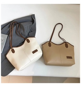 Detail of minimalist cream and khaki tote bags with leather trim and fashion labels