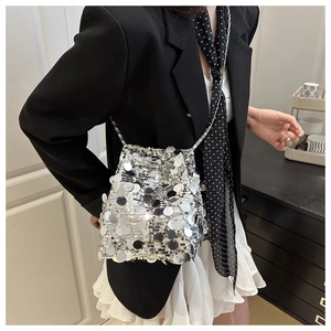 Detail showing shiny silver sequins and metallic chain strap of the trendy bucket bag
