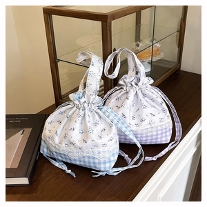 Detail view of floral drawstring handbag with lace trim and check pattern base