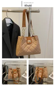 Detail of khaki quilted tote bag with diamond stitching and gold chain strap