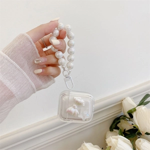 Close-up of clear AirPods case with bow detail and large white pearl bead bracelet strap