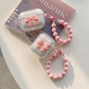 Detailed view of clear AirPods case featuring pink bow and large pearl bead bracelet
