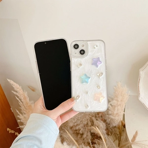 White textured iPhone case with colorful 3D stars and rhinestones held in a cozy setting