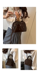 Detailed view of dark brown patent leather shell bag with gold hardware and top handles