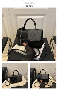 Detail view of black patchwork handbag featuring mixed leather and woven texture panels
