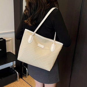 Minimalist beige woven tote bag with slim straps and fashion label in daily use