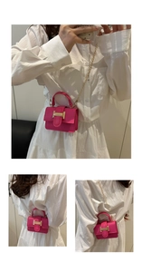 Detail view of mini rose pink handbag with gold H buckle and chain strap on model
