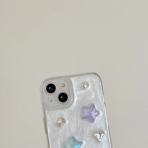 Close-up of star ornaments and glittering rhinestones on a pearlescent iPhone case