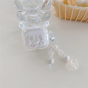 Macro shot of transparent AirPods Pro case with 3D laser bow and pearl pendant charm