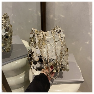 Détail du sac seau montrant des paillettes métalliques géantes et une bandoulière chaîne