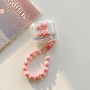 Close-up of clear AirPods case with pink bow and aurora pearl bracelet accessory