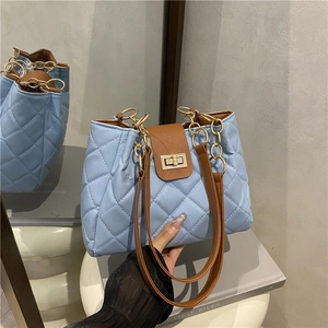 Light blue quilted shoulder bag with gold chain strap and brown leather handles