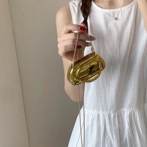 Elegant gold metallic mini crossbody bag with glossy finish and delicate chain strap