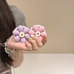 Close-up of pink and purple resin flower phone grips with heart-shaped metal centers