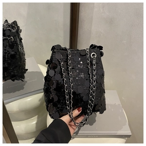 Vue détaillée du sac seau noir à paillettes avec bandoulière chaîne et cordon serrage