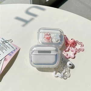 Detail of transparent AirPods case with cute pink bear charm and star keychain