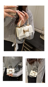 Detail view of cream white mini crossbody bag with gold metal buckle and chain strap