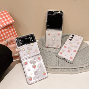 Sparkly clear Samsung Z Flip 6 case featuring 3D pink strawberries and pearl hearts
