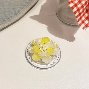Macro detail of a 3D shell flower phone grip with pearl center and yellow gradient petals