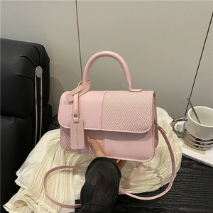Pink patchwork crossbody bag with woven texture and top handle in a minimalist style