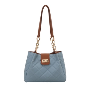 Quilted tote bag in blue and brown patchwork with gold chain straps and metal twist lock